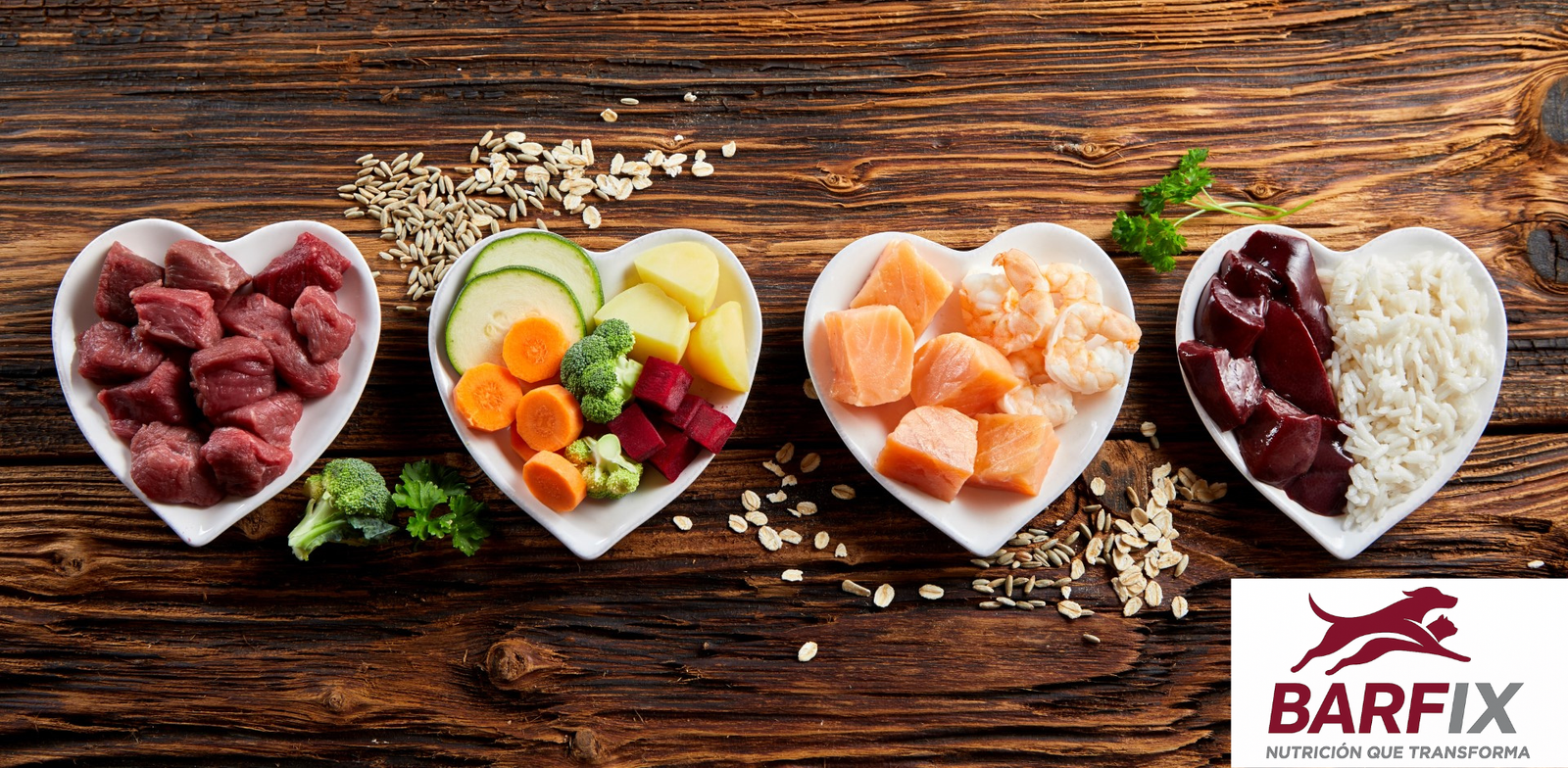 Cuatro platos con carne, pescado, vísceras y vegetales frescos como base de la alimentación BARF para perros y gatos sobre fondo de madera